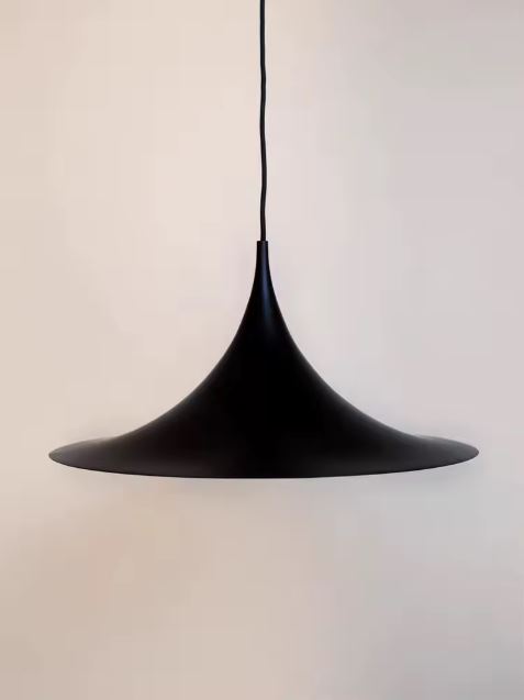 Suspension conique noire mate à large courbe basse, silhouette moderniste entre bauhaus, vintage 50 et minimalisme.