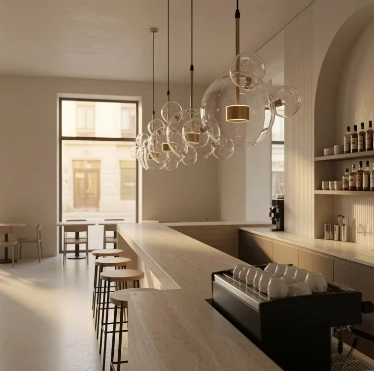 En enfilade au-dessus d'un comptoir de café, des suspensions nuage de bulles en verre soufflé soulignent un décor épuré.