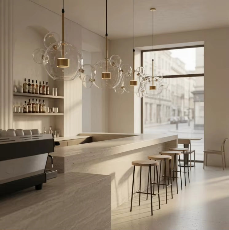 Alignées au-dessus d'un long comptoir, quatre suspensions à bulles en verre soufflé créent une ambiance moderne et épurée.