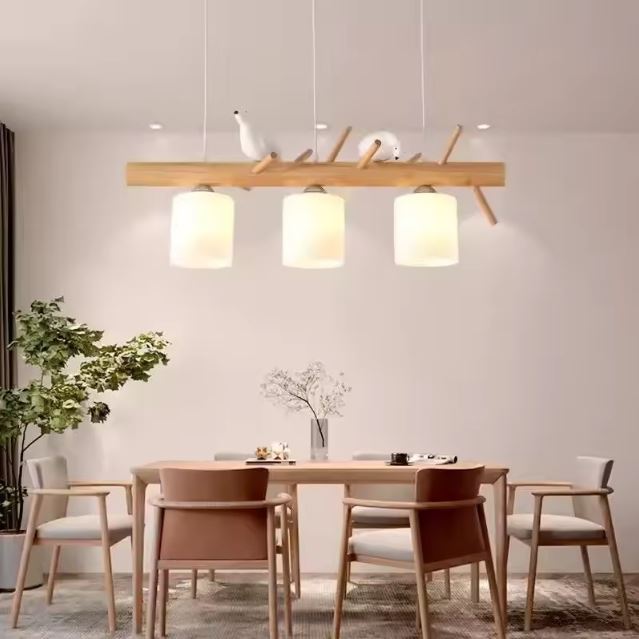 Suspension en bois avec trois abat-jours et oiseaux décoratifs, parfaite pour une salle à manger élégante et lumineuse.