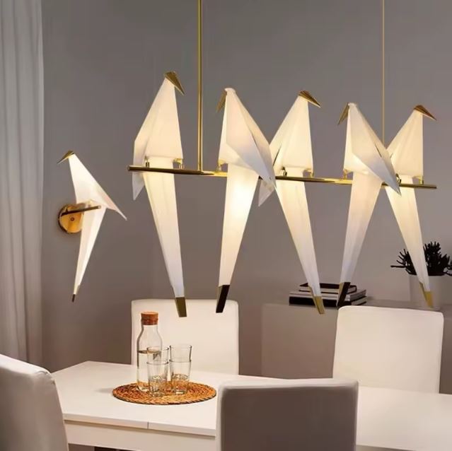 Suspension oiseau origami moderne avec plusieurs oiseaux lumineux perchés sur une branche dorée, idéale pour une salle à manger élégante.