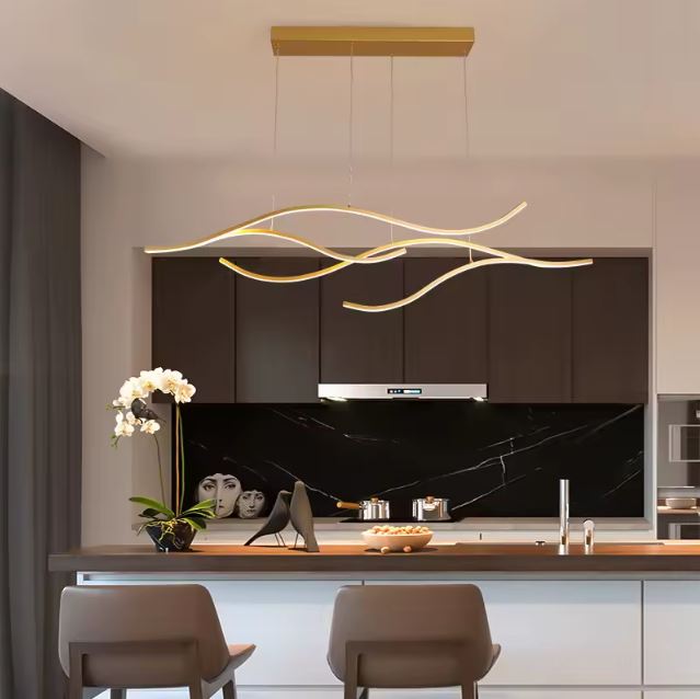 Suspension ondulée LED dorée raffinée, idéale pour éclairer une cuisine moderne noire.