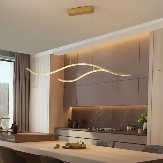 Suspension ondulée LED dorée raffinée, idéale pour illuminer une cuisine moderne.