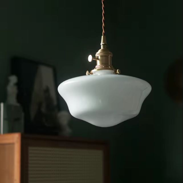 Suspension en opaline blanche avec un design vintage, apportant une touche rétro élégante à une pièce sombre et raffinée.