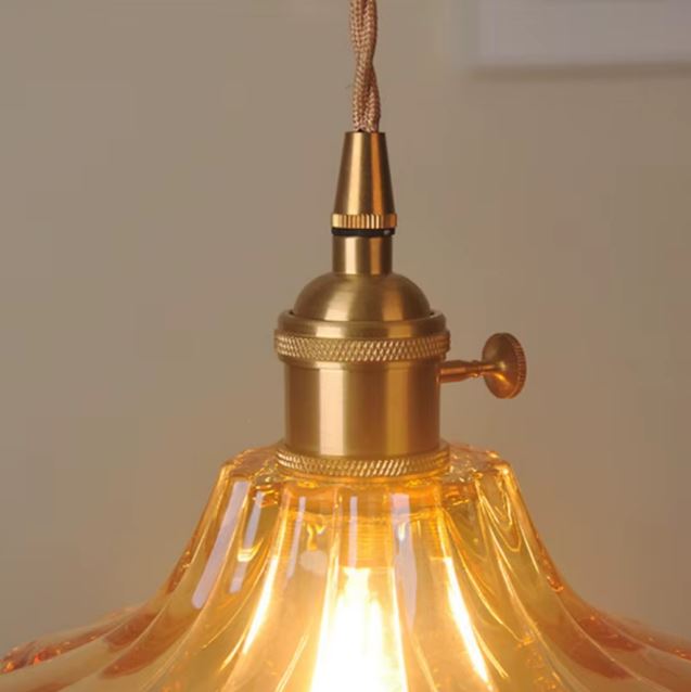 Détail de la suspension orange vintage montrant la douille en laiton et le verre rétro lumineux et raffiné.