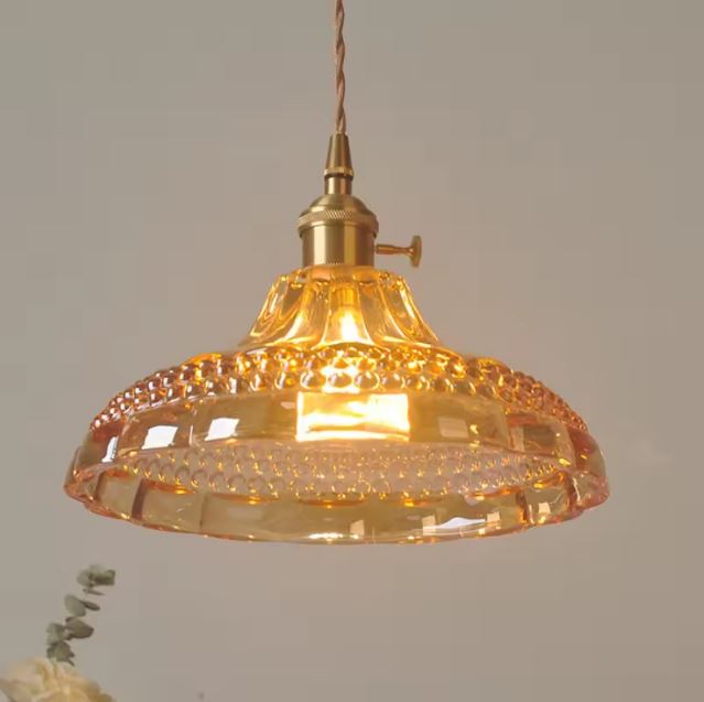 Suspension orange vintage en verre orangé ambré, apportant une touche décorative et lumineuse à différents styles d'intérieur.