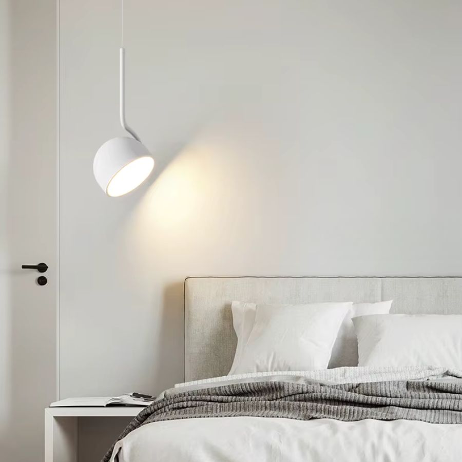 Suspension blanche orientable près du lit dans une chambre scandinave, lumineuse et minimaliste