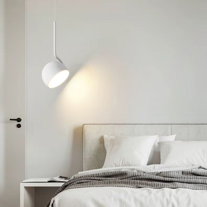 Suspension blanche orientable près du lit dans une chambre scandinave, lumineuse et minimaliste
