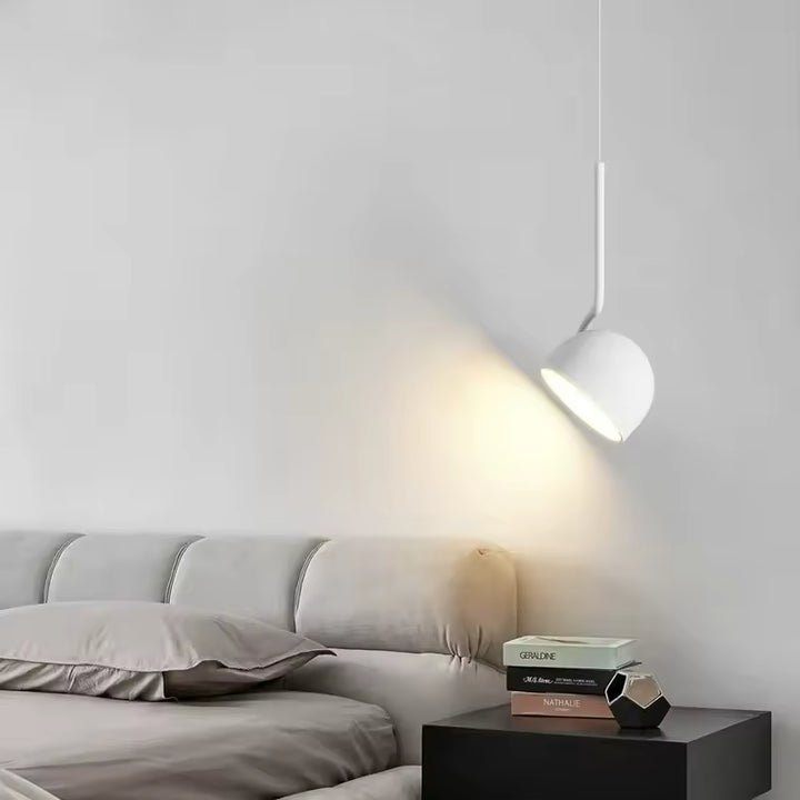 Luminaire suspendu blanc à coupole orientable près du lit, dans une chambre design sobre et contemporaine
