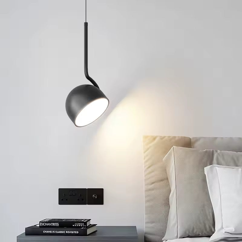 Suspension noire orientable près du lit, avec coupole inclinable dans une chambre moderne et minimaliste