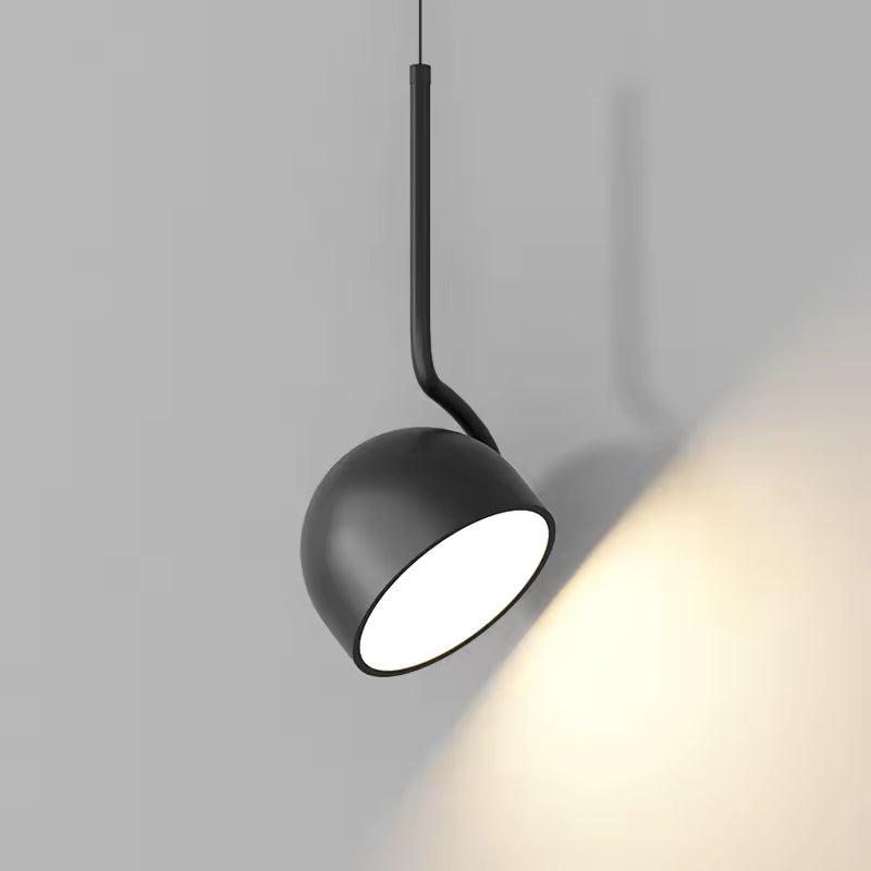 Vue rapprochée d’une suspension noire à coupole inclinable, au style contemporain avec lumière directionnelle