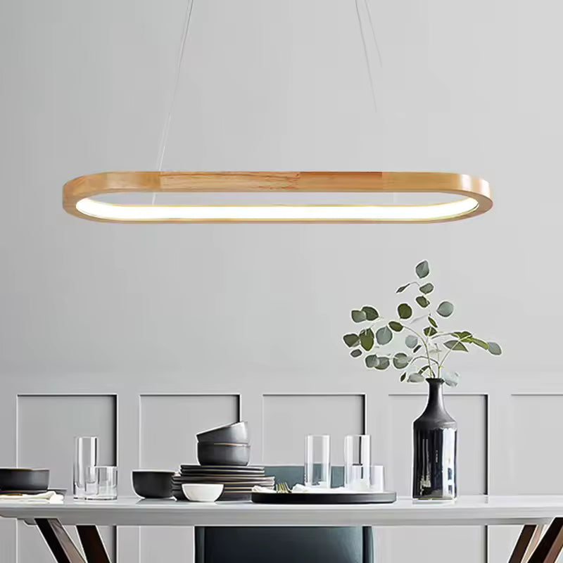 Au-dessus de la table, cette suspension ovale en bois à LED intégrée affirme un style scandinave, épuré et moderne