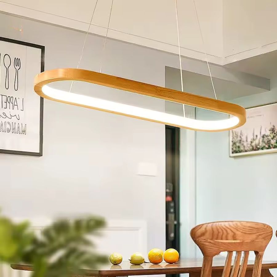 Au-dessus de la table, cette suspension ovale en bois diffuse une lumière LED douce dans un décor moderne et naturel