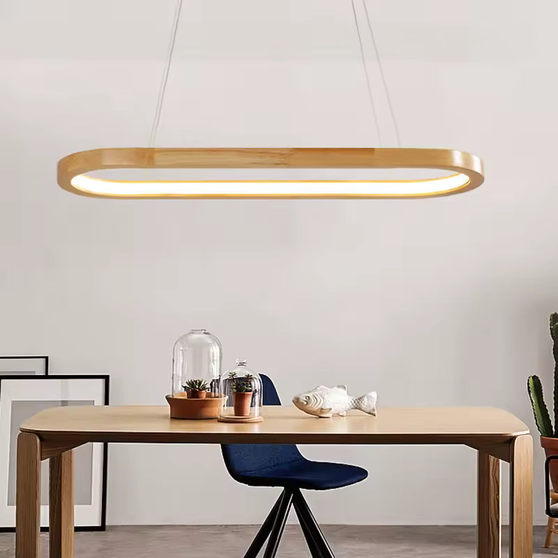 Suspendue au-dessus d’une table en bois, cette LED ovale associe lignes minimalistes et inspiration scandinave