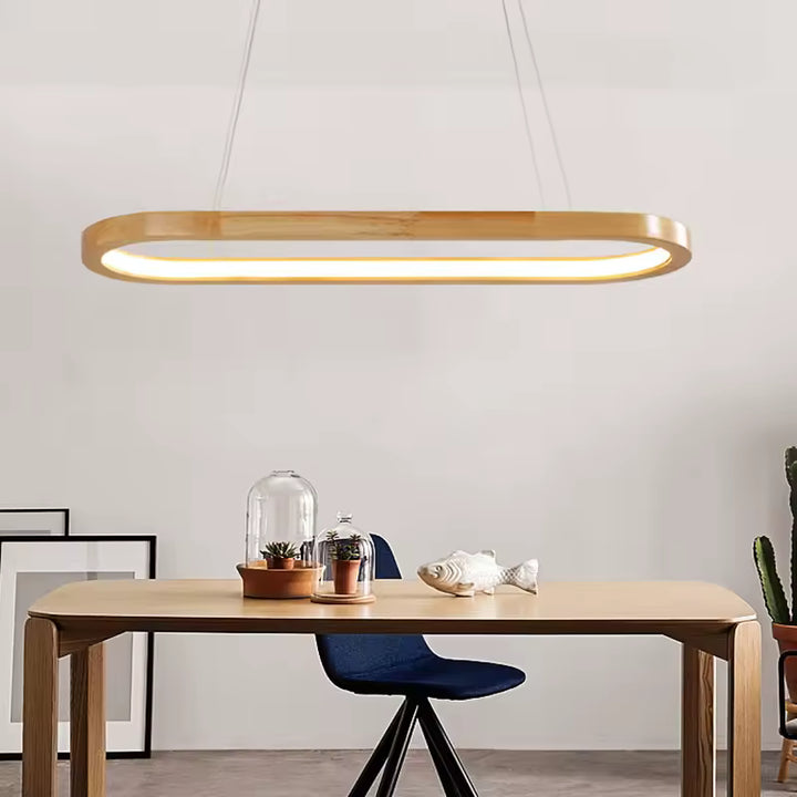 Suspendue au-dessus d’une table en bois, cette LED ovale associe lignes minimalistes et inspiration scandinave