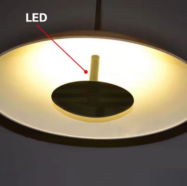 Zoom sur la suspension ovni avec éclairage LED intégré, offrant une lumière chaude et homogène pour un intérieur moderne et raffiné.
