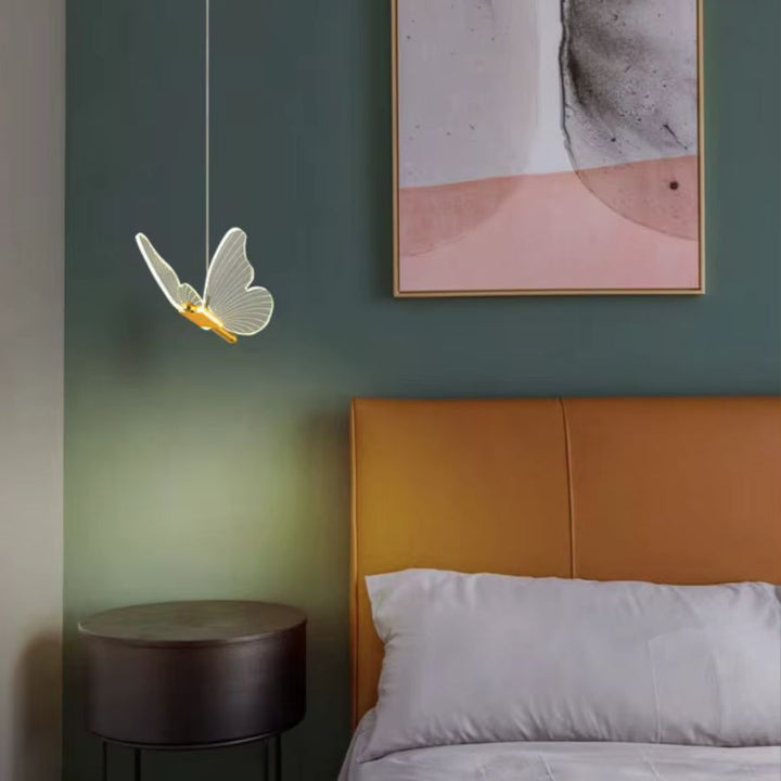 Près du lit, un papillon lumineux suspendu apporte une touche délicate et contemporaine à la chambre