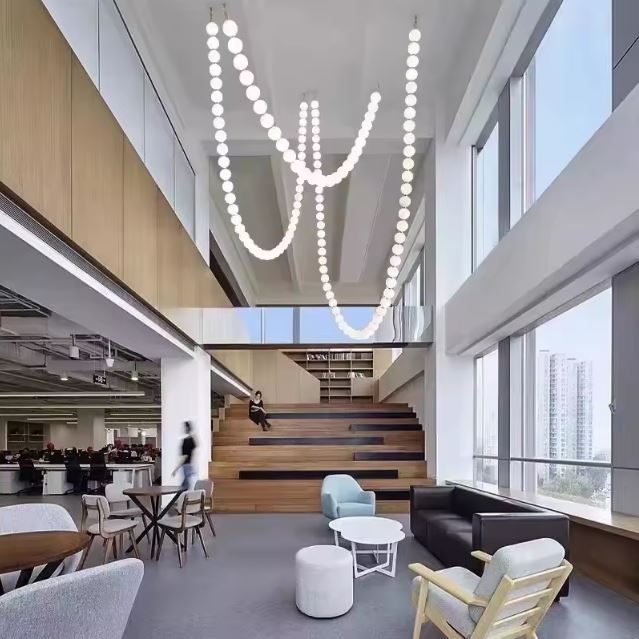 Suspension perle élégante et lumineuse installée dans un espace de bureau moderne et lumineux pour un design unique.