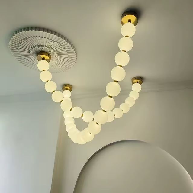 Suspension perle luxueuse au plafond, combinant élégance et design moderne pour sublimer un intérieur épuré.