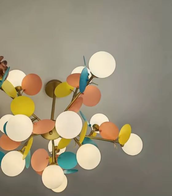 Détail des globes opalins lumineux et pétales colorés d'une suspension florale au design joyeux et contemporain.