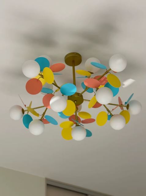 Suspension à pétales multicolores et globes opalins, au design floral ludique mêlant influences pop et contemporaines.