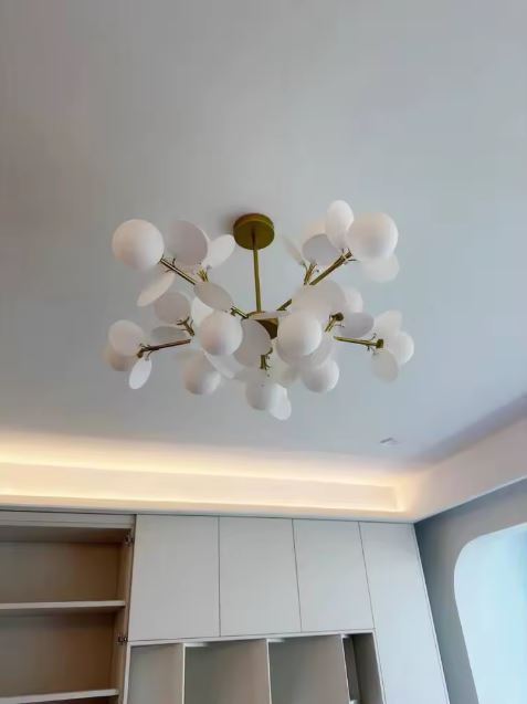 Suspension à pétales blancs et globes opalins, déployée en branches aériennes au design organique et contemporain.