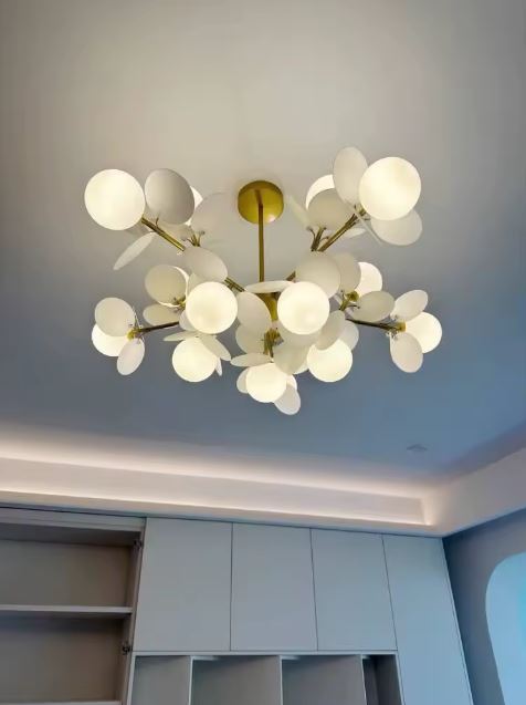 Suspension florale à pétales blancs et globes opalins lumineux, évoquant un bouquet aérien au style poétique et moderne.