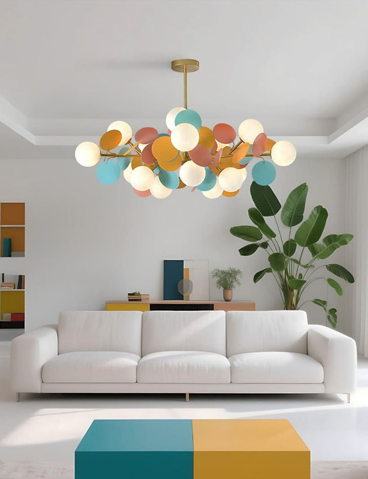 Grande suspension multicolore et boules blanches en verre opalin aux formes organiques installée dans un salon spacieux et baigné de lumière.