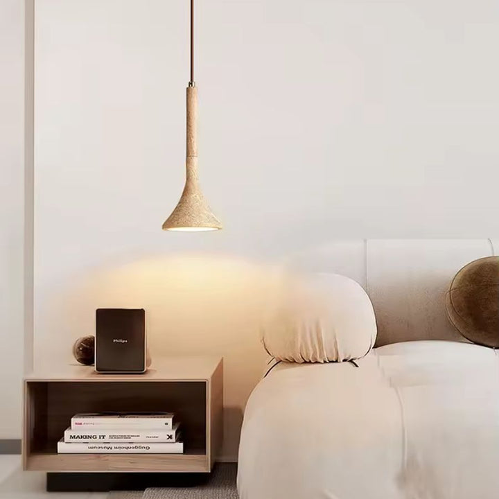 Au-dessus du chevet, la suspension en pierre et bois diffuse une lumière chaude dans une chambre contemporaine apaisante