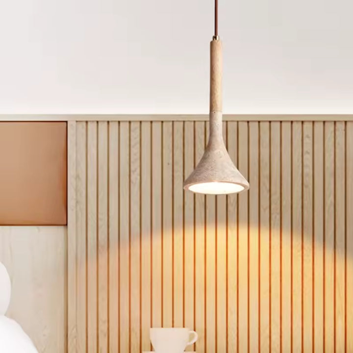 Devant un mur en tasseaux, la suspension en pierre et bois clair diffuse une lumière douce au style naturel épuré