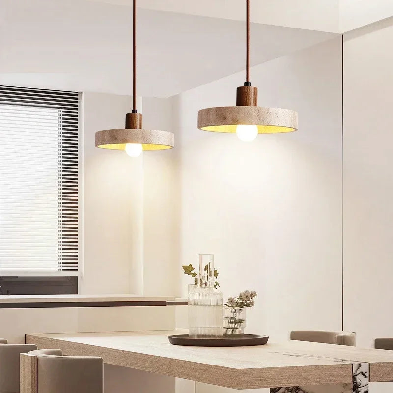 Suspension en pierre naturelle et bois foncé installée au-dessus d'une table à manger dans une salle à manger moderne.