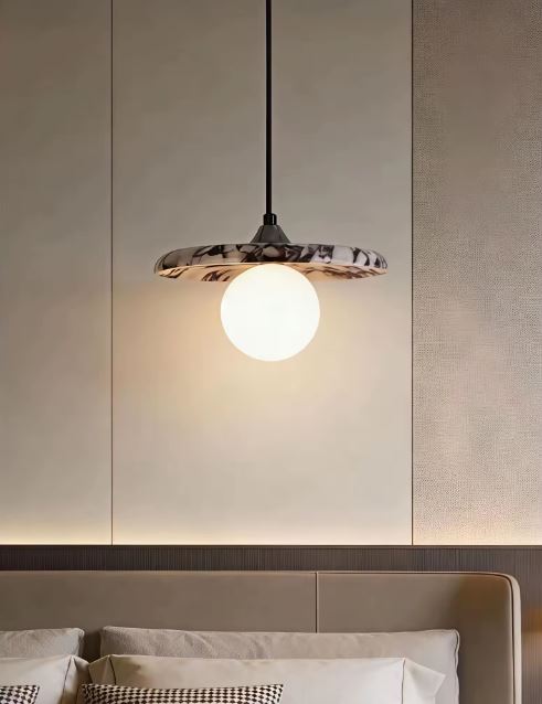 Suspension en pierre naturelle suspendue au-dessus d'un lit, dans un style contemporain, organique, minimaliste et luxueux