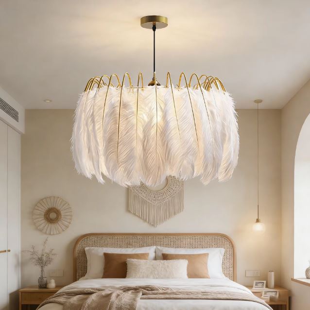 Suspension à plumes blanches et structure dorée dans une chambre, ambiance bohème chic et lumineuse.