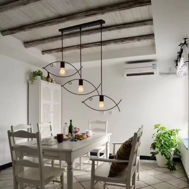 Suspension poisson triple en métal noir, idéale pour une décoration rustique et élégante dans une salle à manger chaleureuse.
