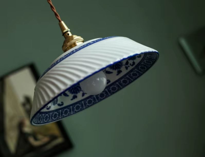 Suspension en porcelaine blanche nervurée à frise florale bleue, au charme artisanal délicat, idéale pour une déco classique, romantique ou même campagne chic.