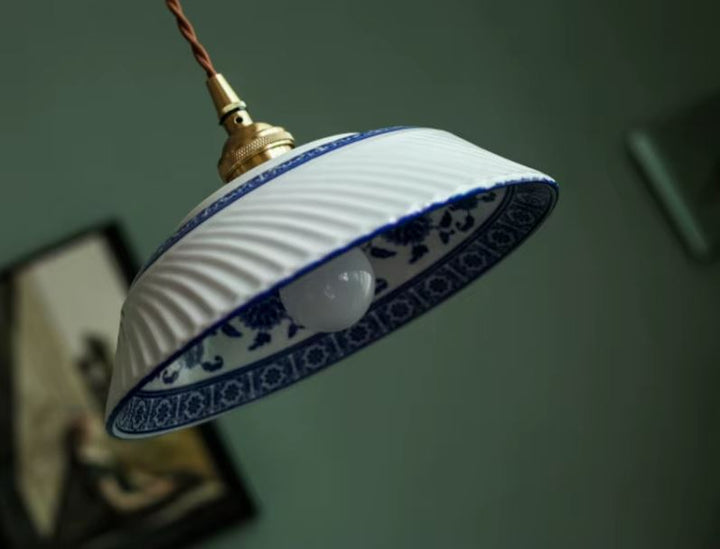 Suspension en porcelaine blanche nervurée à frise florale bleue, au charme artisanal délicat, idéale pour une déco classique, romantique ou même campagne chic.
