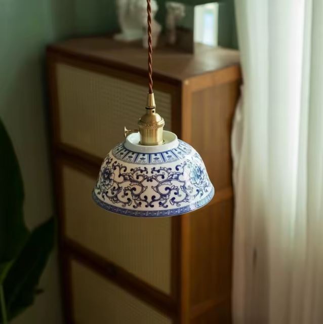 Suspension en porcelaine blanche aux tracés bleus délicatement ouvragés, parfaite pour un décor vintage élégant ou une ambiance artisanale raffinée.