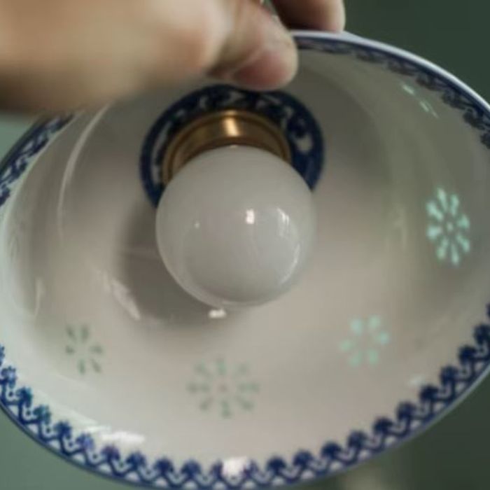 Suspension en porcelaine fine aux arabesques bleues ajourées, détail intérieur révélant son style artisanal rétro et campagne chic.