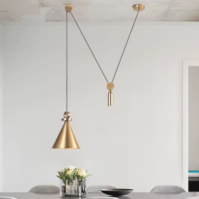 Suspension à poulie au design moderne en laiton, idéale pour éclairer une table avec un luminaire élégant et fonctionnel.