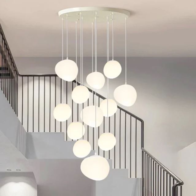 Suspension pour cage d'escalier design avec plusieurs boules blanches, parfaite pour un éclairage élégant et moderne.