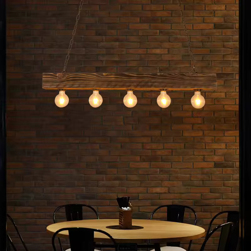 Suspension en poutre de bois à cinq ampoules apparentes, au style loft industriel devant un mur en briques