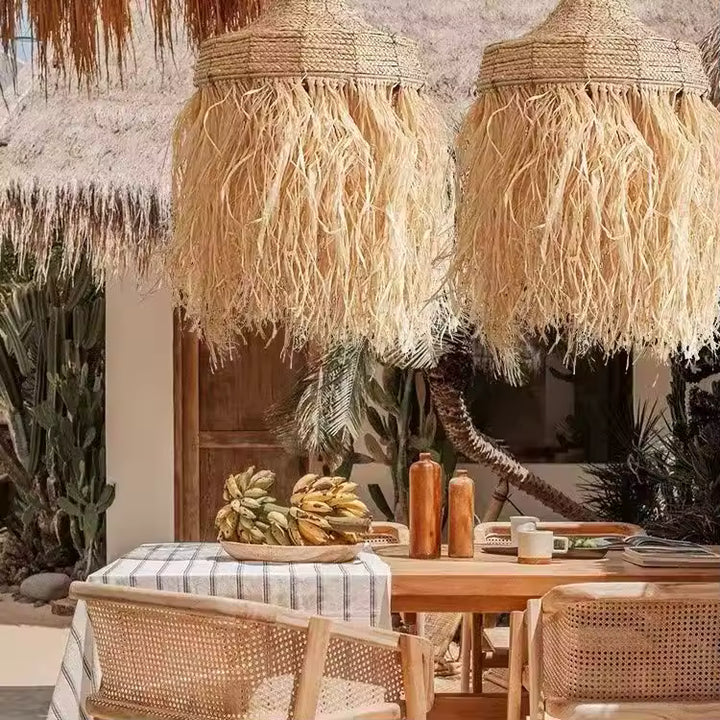 Suspension raphia à longues franges au-dessus d’une table, dans une ambiance bohème naturelle et exotique