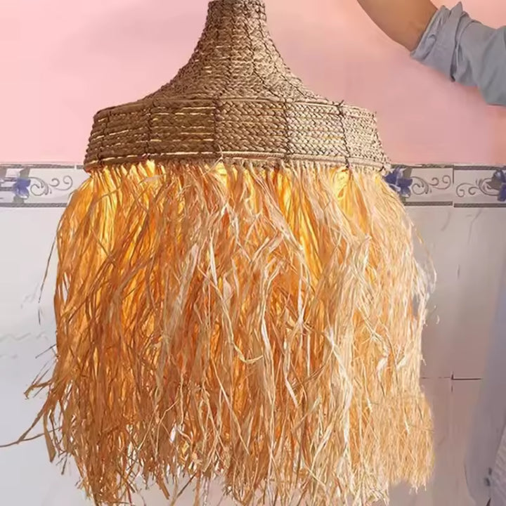 Suspension raphia à longues franges diffusant une lumière chaude, au style naturel et bohème artisanal