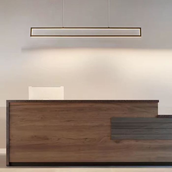 Suspension rectangulaire au-dessus d’un comptoir de réception en bois, parfaite pour un espace professionnel au design minimaliste.
