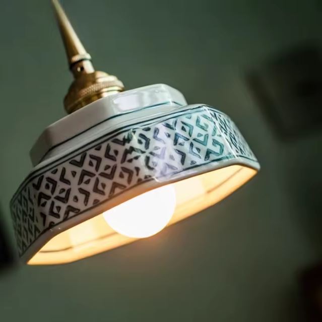 Suspension rétro en céramique émaillée avec motifs géométriques, style vintage et artisanal, idéale pour éclairer un salon ou un bureau moderne.