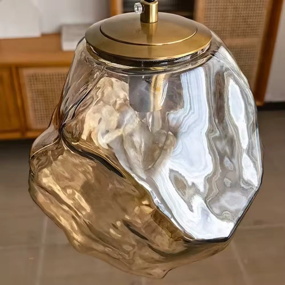 Luminaire suspendu en verre sculptural ambré aux formes organiques et détails dorés, esprit design contemporain