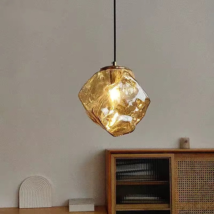 Éclat ambré et silhouette minérale pour cette suspension en verre sculpté au style organique et contemporain