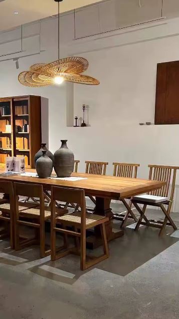 Suspension en rotin artistique au style japandi, luminaire naturel et élégant au-dessus d’une grande table en bois.