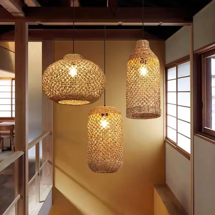 Trois suspensions en rotin ajouré aux formes variées éclairent une cage d'escalier au style japonais et naturel.