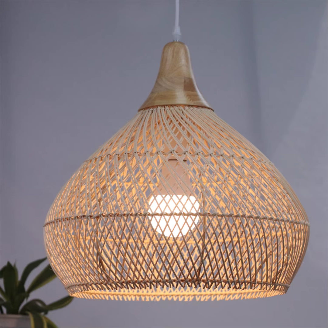 Éclairée de l’intérieur, cette suspension en rotin naturel et bois révèle un style bohème, organique et chaleureux